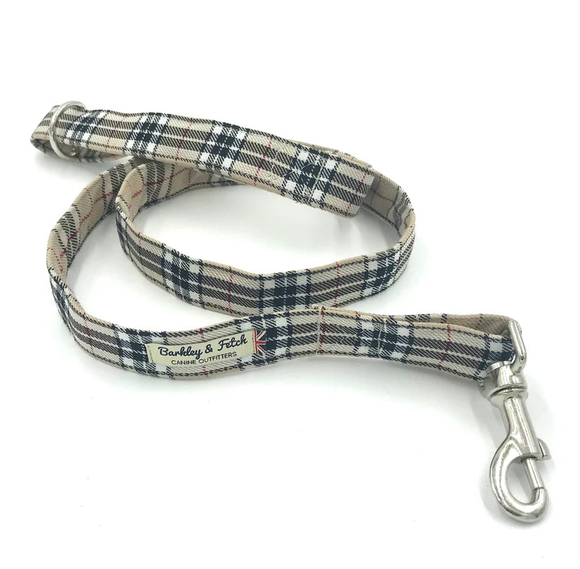 A dog lead with a tartan pattern in beige, brown, and black colors, featuring a comfortable loop handle and a strong steel trigger clip.