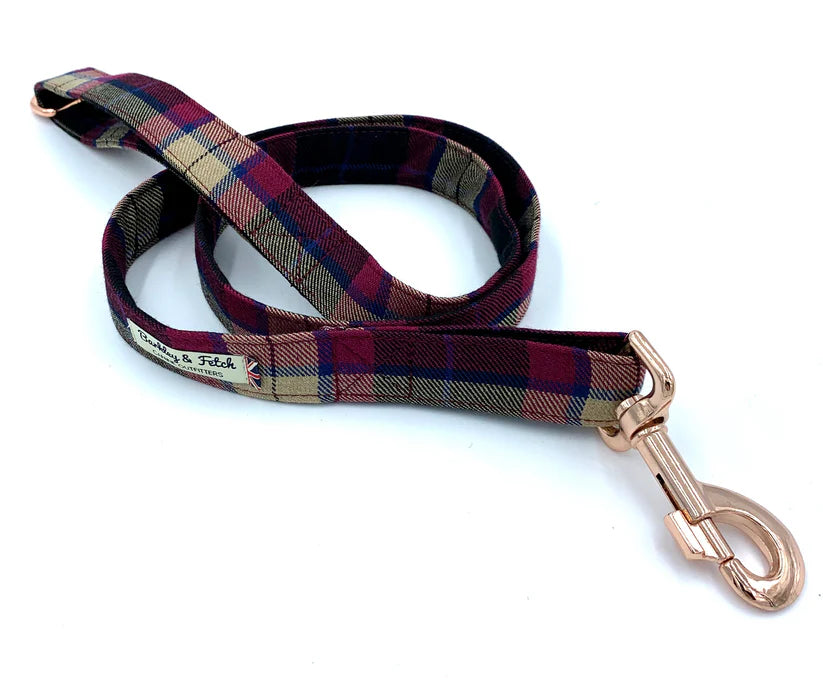A wine tartan dog lead with a comfortable loop handle, an accessory attachment ring, and a strong, gold-coloured steel trigger clip.