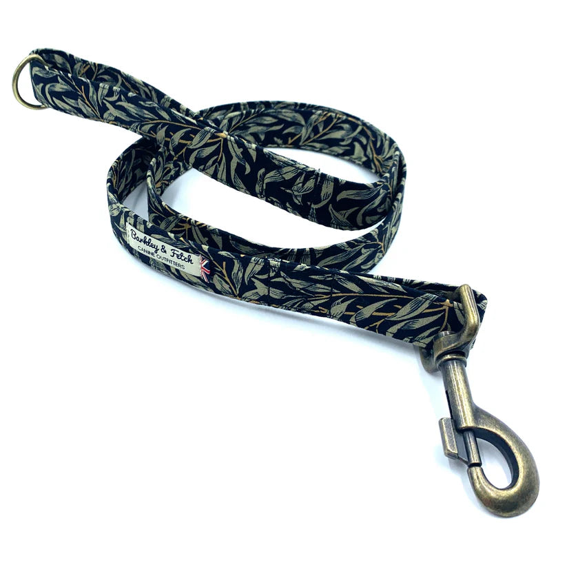 A dog lead with a willow print design, predominantly in shades of green and black, with a loop handle and metal trigger clip.