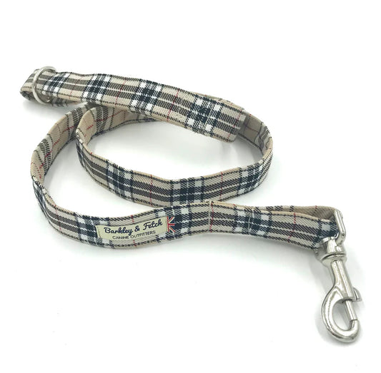 A dog lead with a tartan pattern in beige, brown, and black colors, featuring a comfortable loop handle and a strong steel trigger clip.