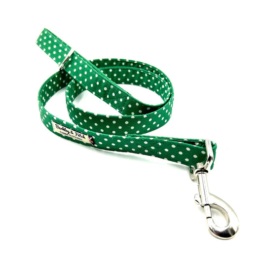 A green and white spotty dog lead with a loop handle and a strong steel trigger clip.