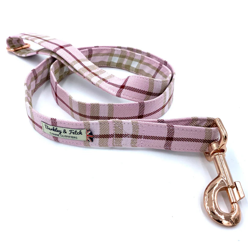 A pale pink tartan dog lead with a comfortable loop handle, an accessory attachment ring, and a strong rose-gold coloured steel trigger clip.