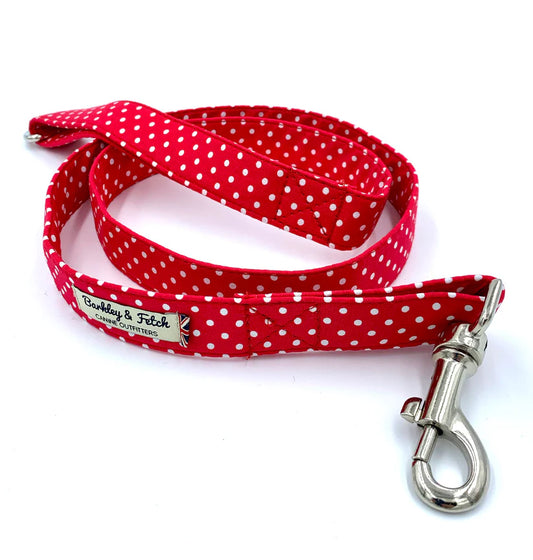 A red and white spotty dog lead with a metal clasp and a label showing the brand name 'Barkley & Fetch'.
